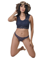 Woman wearing a navy blue lace bikini with a matching hat on a white background
