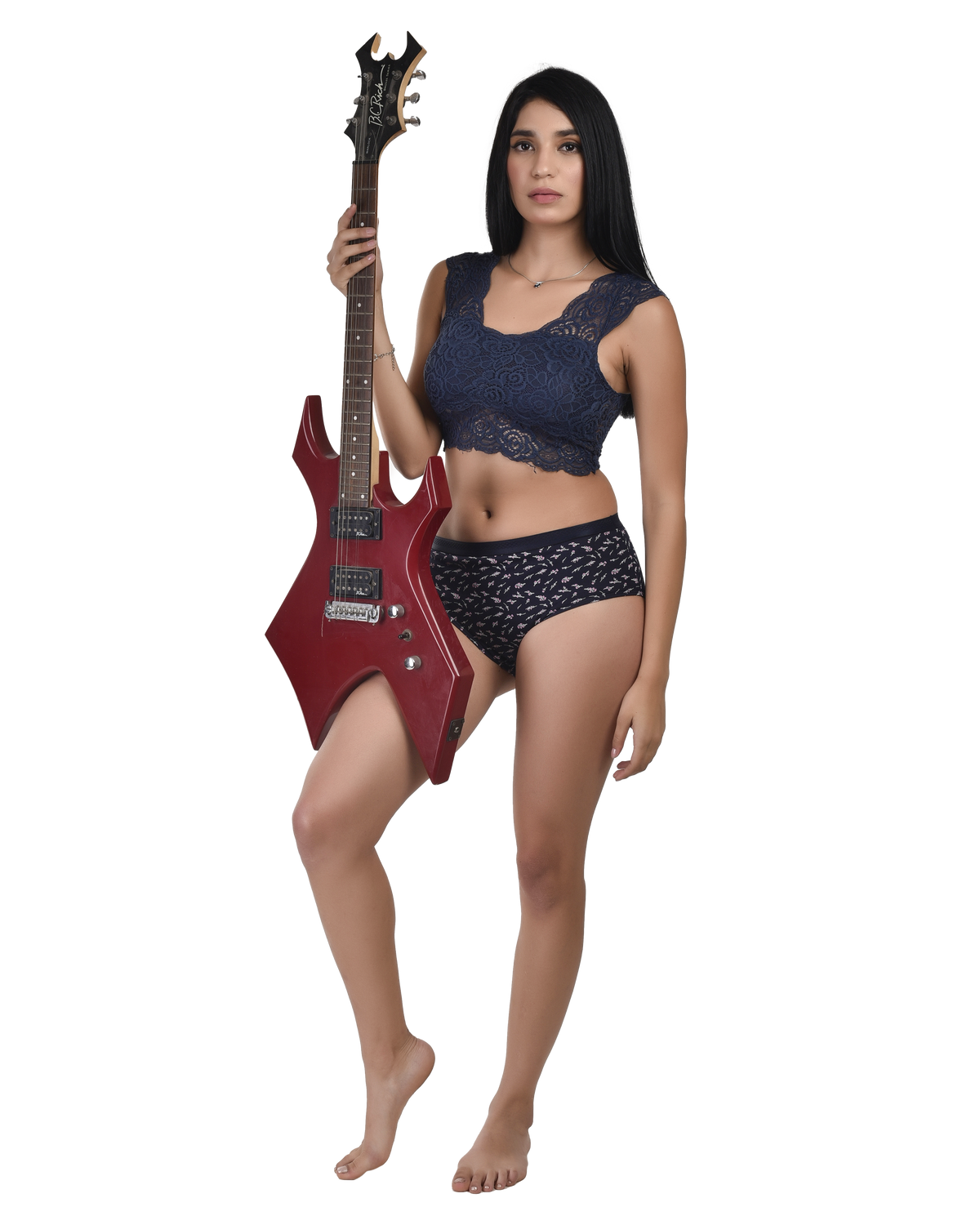 Woman holding a red electric guitar wearing a dark blue lace top and patterned underwear on a white background