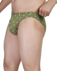 Green polka dot underwear worn by a person on a white background