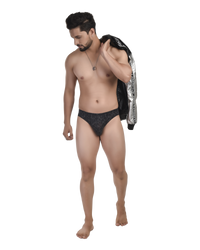 Man wearing black underwear with a jacket over his shoulder on a white background