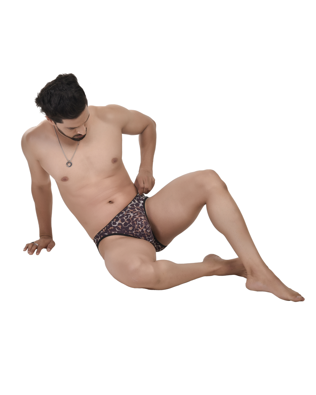 Man sitting on a white background wearing patterned underwear