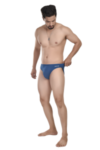 Man wearing a blue swim brief on a white background